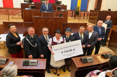 Przedstawiciele OSP Danków i KGW Danków odbierają symboliczny czek poświadczający uzyskanie dotacji w marszałkowskim konkursie.