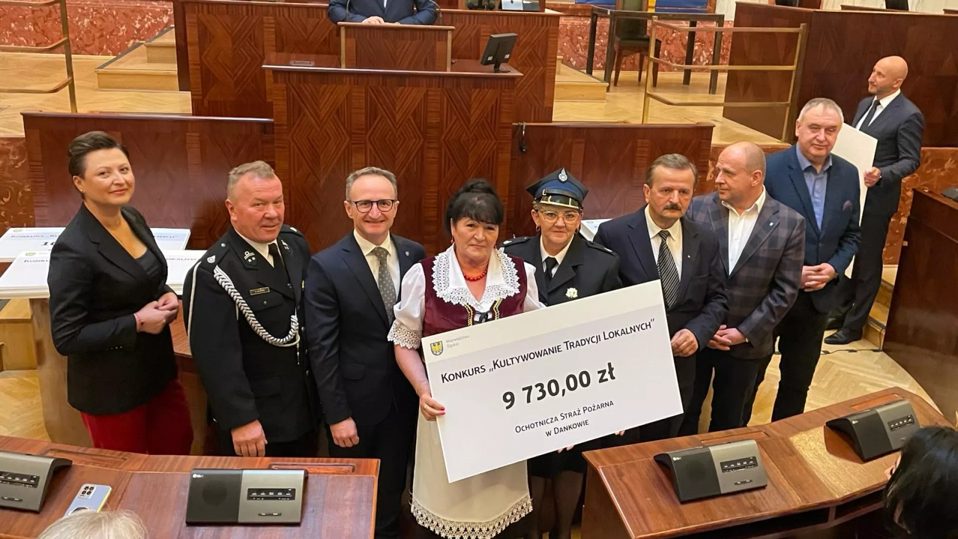 Przedstawiciele OSP Danków i KGW Danków odbierają symboliczny czek poświadczający uzyskanie dotacji w marszałkowskim konkursie.