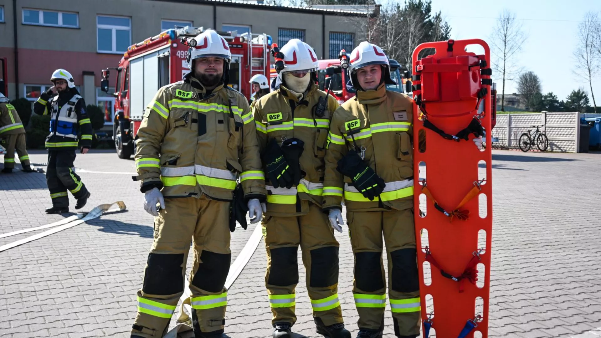 Strażacy z OSP Zbrojewsko na tle samochodów strażackich