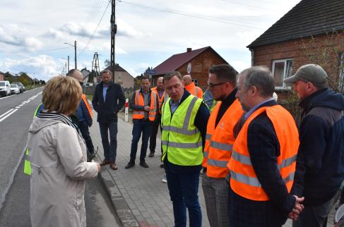 Dyrektor GDDKiA i Wójt Gminy Lipie wraz z innymi osobami omawiają szczegóły realizacji chodnika przy drodze krajowej.