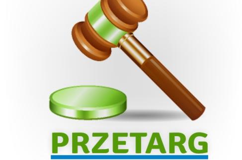 Drewniany młotek uderzający z zielona podstawkę oraz napis przetarg